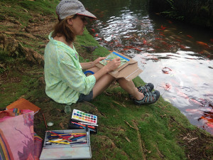 Photo of Nanci Hersh painting at Byodo-In temple koi ponds
